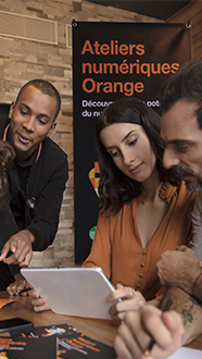 2 hommes et 2 femmes sont accompagné d'un ambassadeur Orange lors d'un atelier numérique