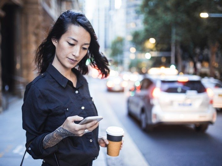 Photo d'une femme appelant un taxi avec son téléphone