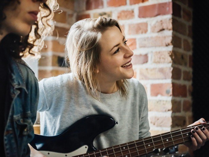 Photo d'une musicienne guitare à la main