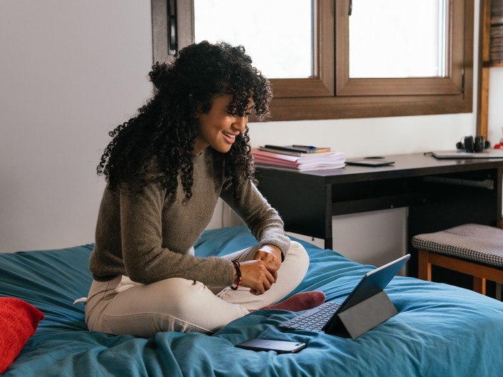 Photo d'une femme en vision sur sa tablette à domicile