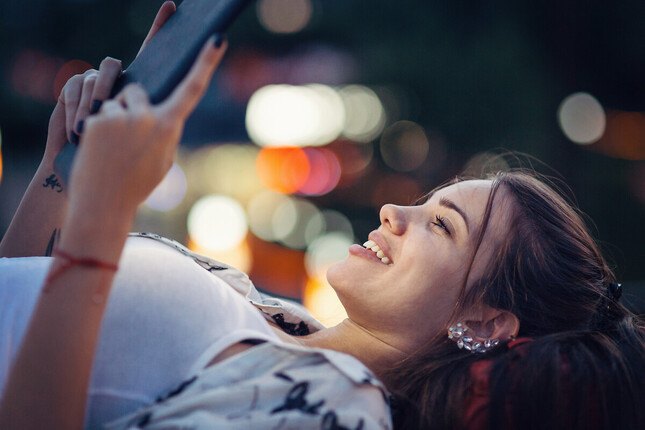 Photo d'une jeune femme regardant sa tablette en extérieur