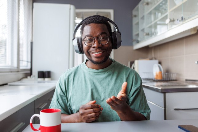 Photo d'un jeune homme en visio dans son logement