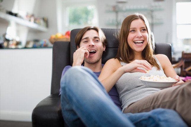 Photo d'un couple regardant une film à la maison