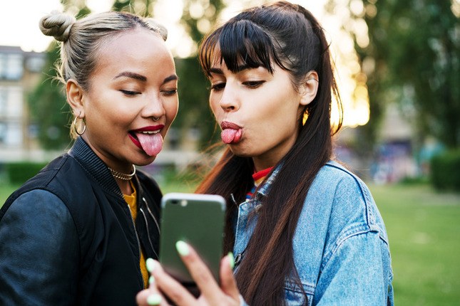 Photo de jeunes se prenant en selfie avec leur smartphone