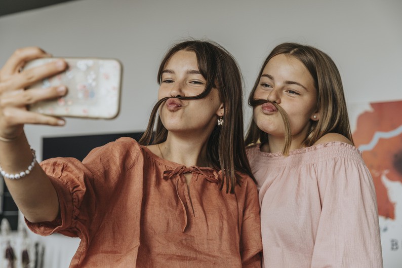 Photo de jeunes filles se prenant en selfie depuis leur chambre d'hôtel