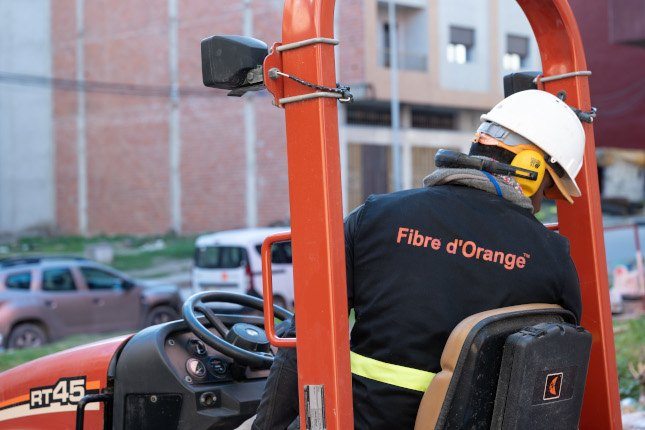 Technicien Orange installant la fibre optique dans une rue