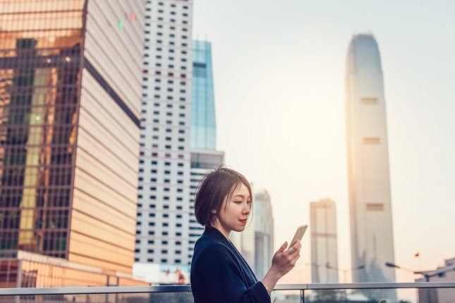 Jeune femme connectée à l’étranger avec un forfait international Orange en ville