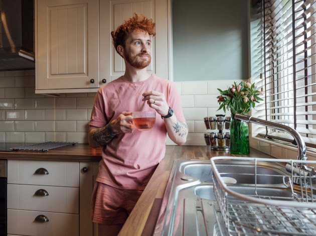 Photo d'un homme dans sa cuisine avec stores aux fenêtres