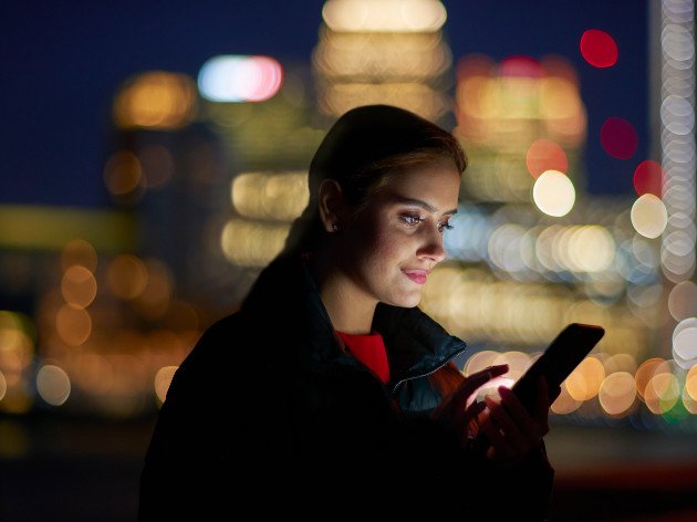 Photo d'une femme activant à distance la simulation de présence à domicile