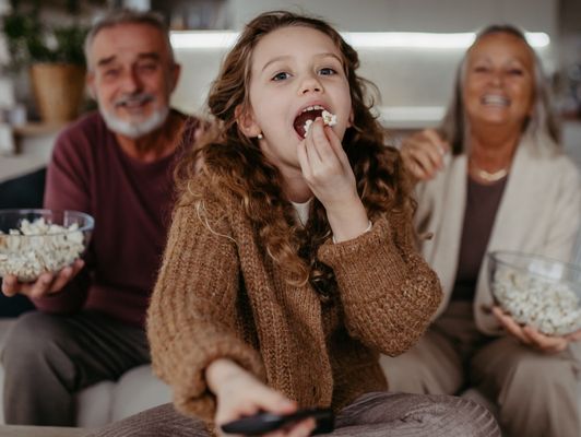 Famille profitant d'un film avec un super débit et en 4K grâce à la Fibre Orange