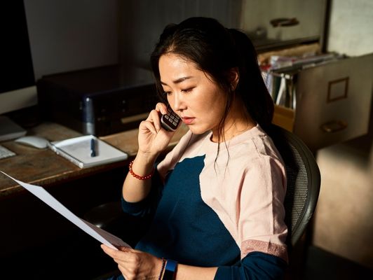 Femme au téléphone avec un conseiller Orange qui répond à ses questions sur la transition vers la Fibre 